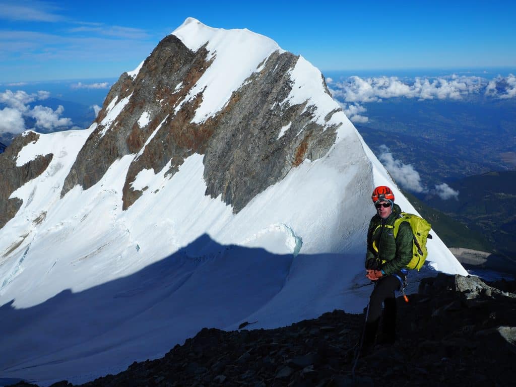 Alpiniste devant l'arête neigeuse de l'aiguille de Bionnassay culminant à 4052m