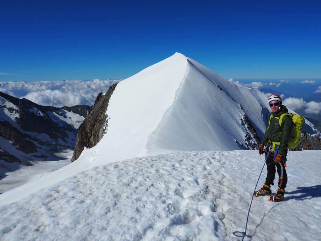 Alpiniste devant la classique arête neigeuse des Domes de Miage